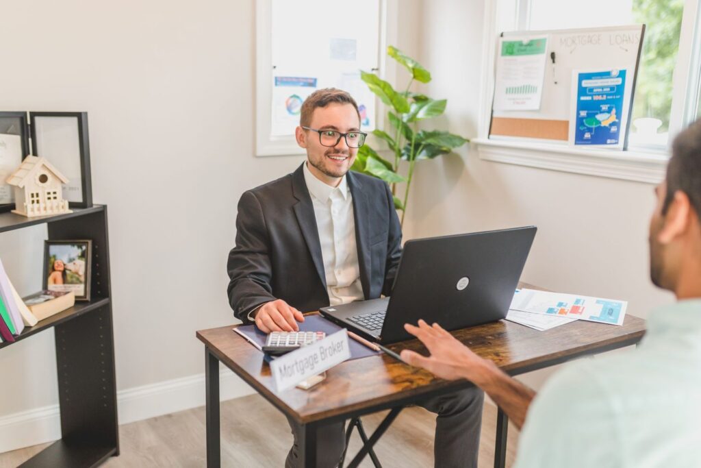 Mortgage broker at an office desk talking with a client