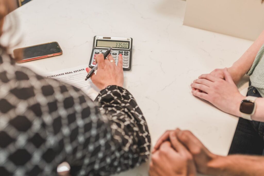 Hands at a table with a calculator while a mortgage is worked out
